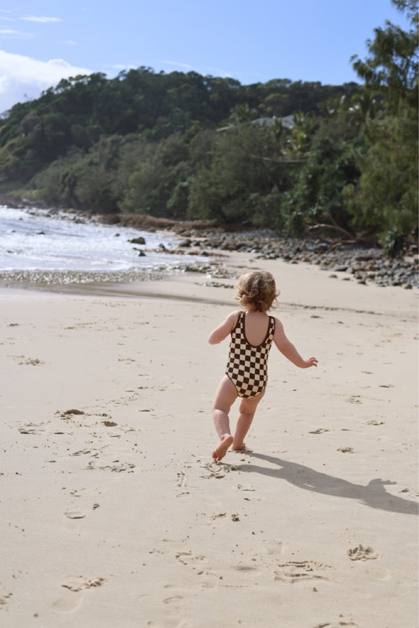 Little girl in sustainable checkered baby swimsuit with low back by Peachy Gang