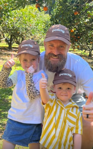 Andrew Redmayne in matching peachy caps with kids